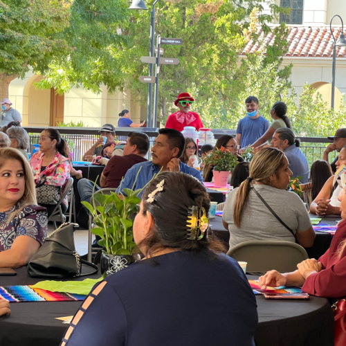 Individuals seated at tables with colorful runners