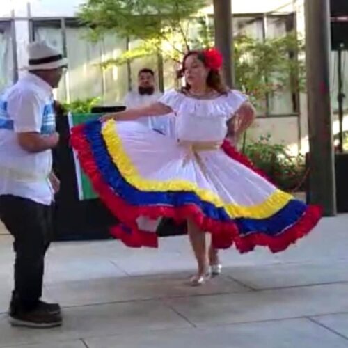 A man and a woman dance to the music during hispanic heritage month